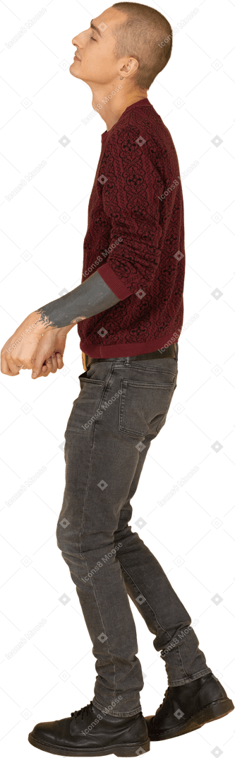 Vue latérale d'un jeune homme dansant vêtu d'un pull rouge