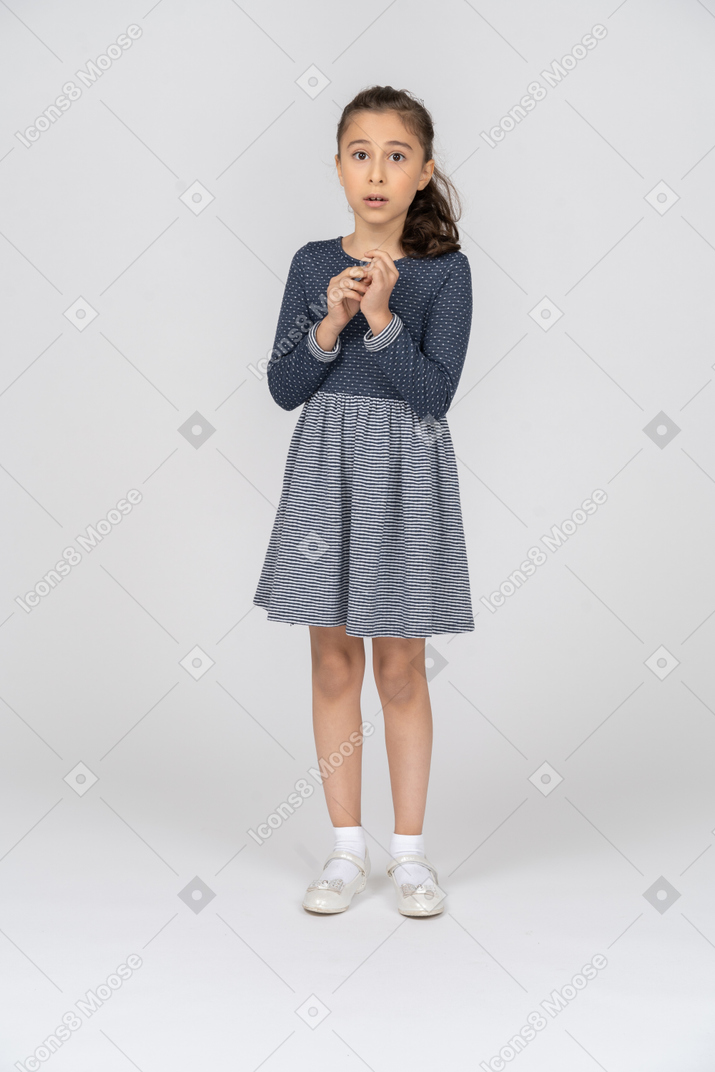Vista frontal de uma garota mexendo com os dedos nervosamente