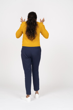 Rear view of an emotional girl in casual clothes