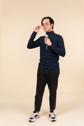 Young asian man speaking into a microphone