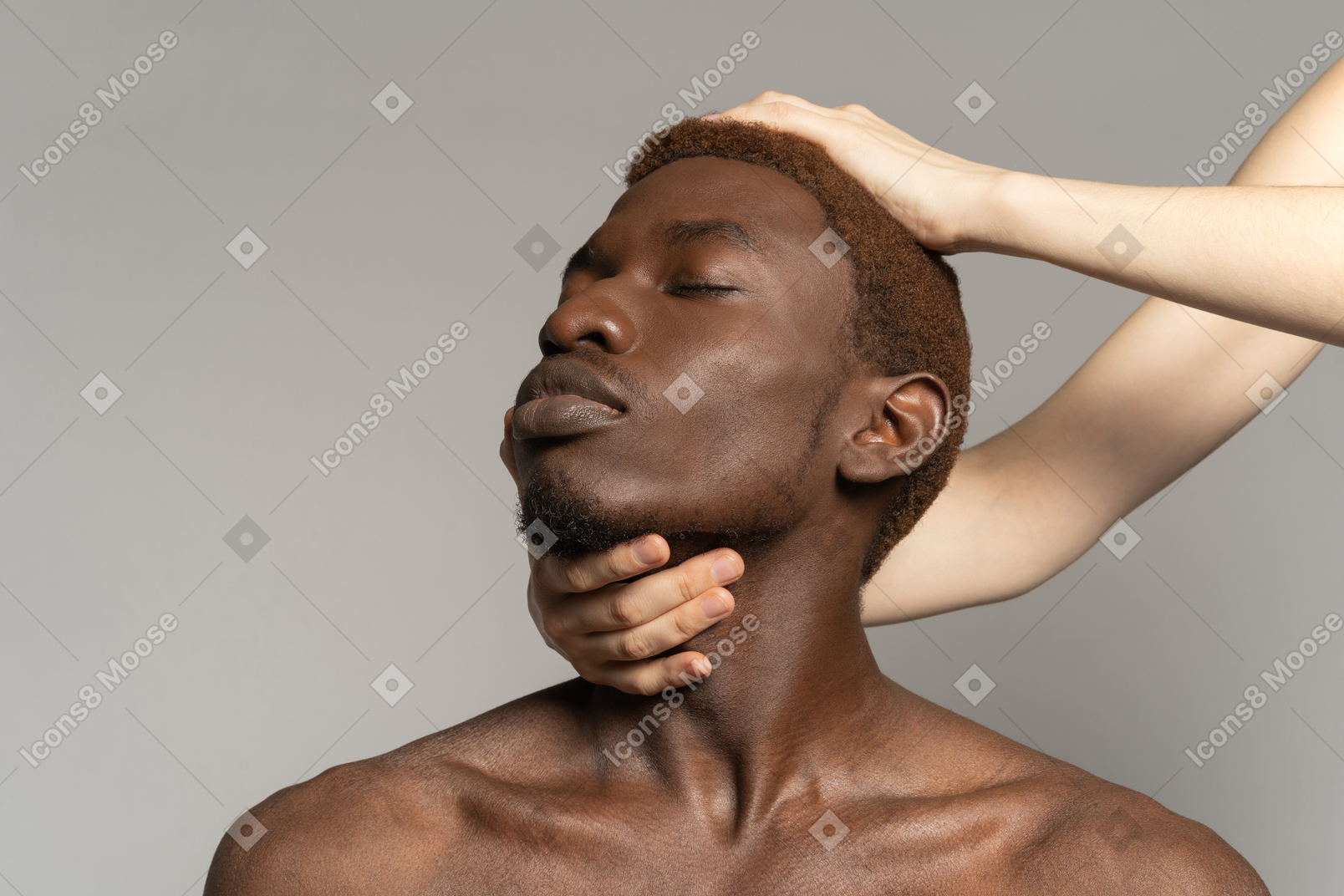 白い手が首と黒人男性の頭に触れる