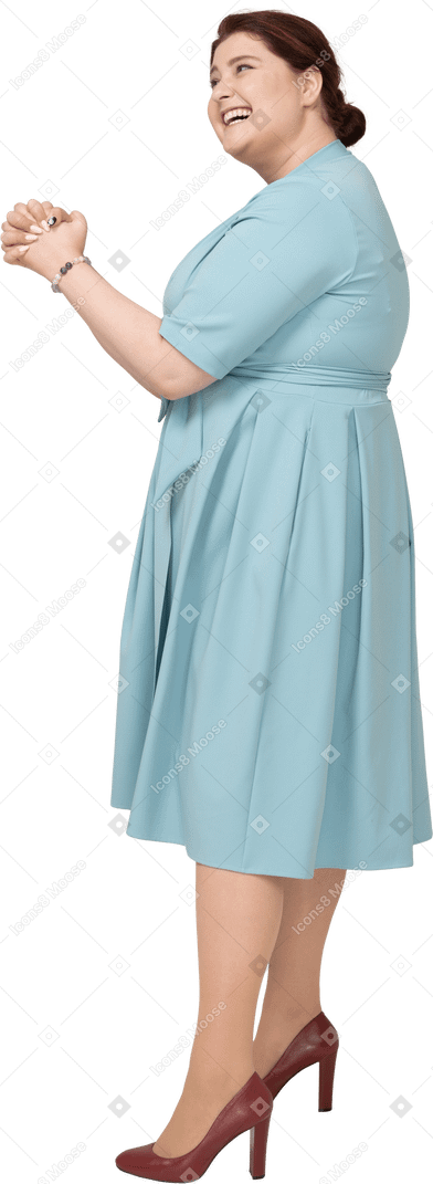 Side view of a happy woman in blue dress gesturing