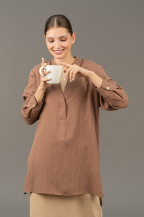 Jeune femme souriante tient une tasse de café