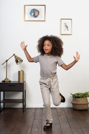 Good looking girl kid posing on the apartment background