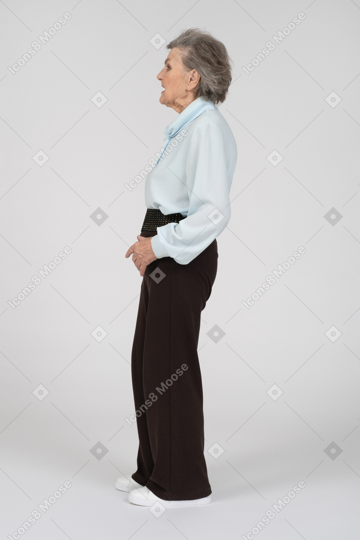 Vista laterale di una donna anziana che fa una smorfia e si spalanca a sinistra