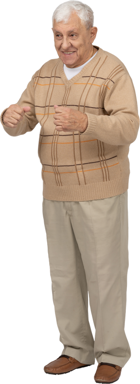 Vue de face d'un vieil homme heureux dans des vêtements décontractés debout avec les poings serrés
