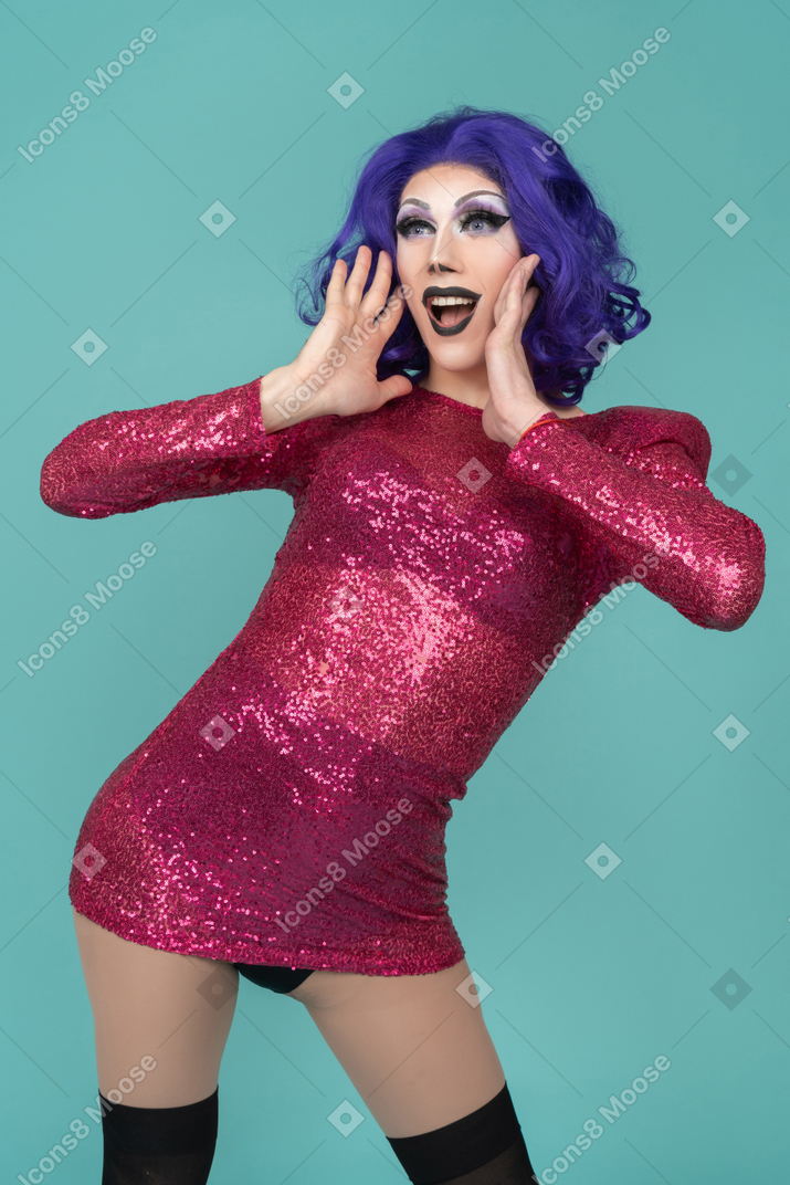 Retrato de uma drag queen chamando com as mãos ao lado da boca