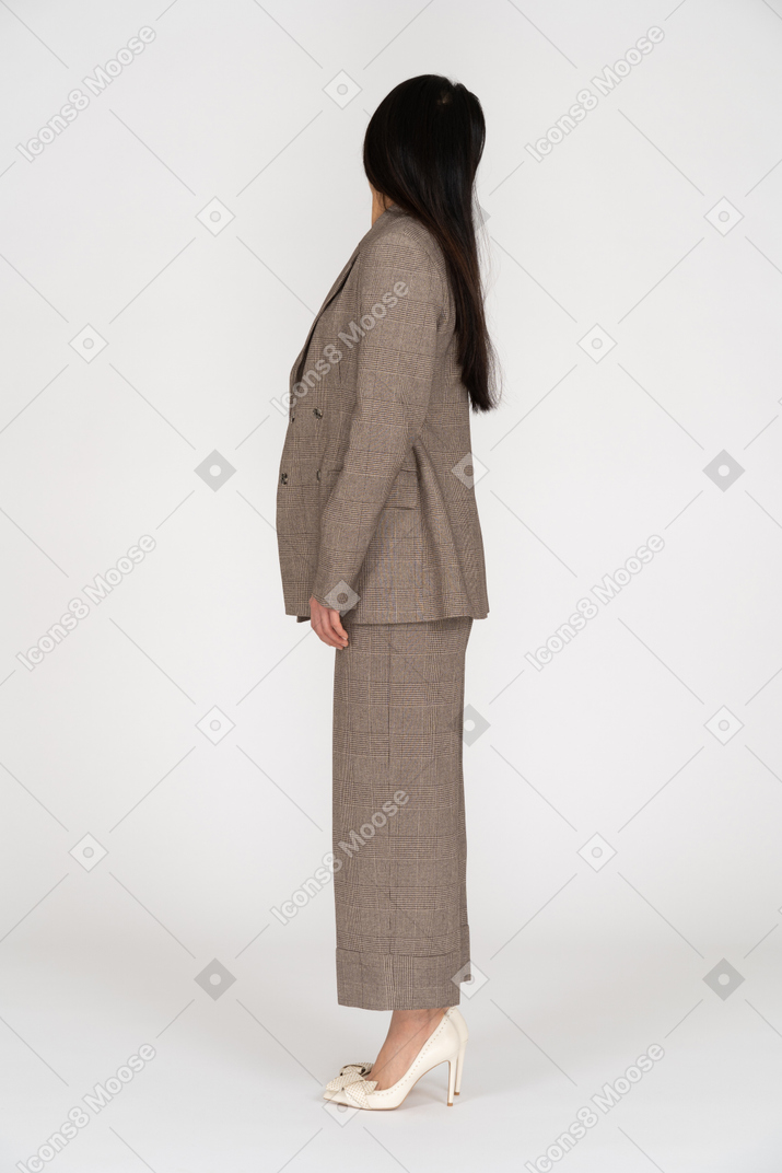 Side view of a young lady in brown business suit turning away