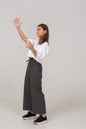 Three-quarter view of a young lady in office clothing showing a size of something