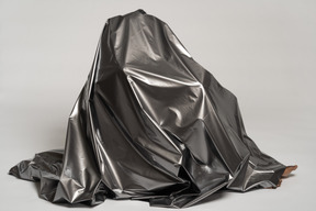 Person sitting on floor fully covered with silver satin