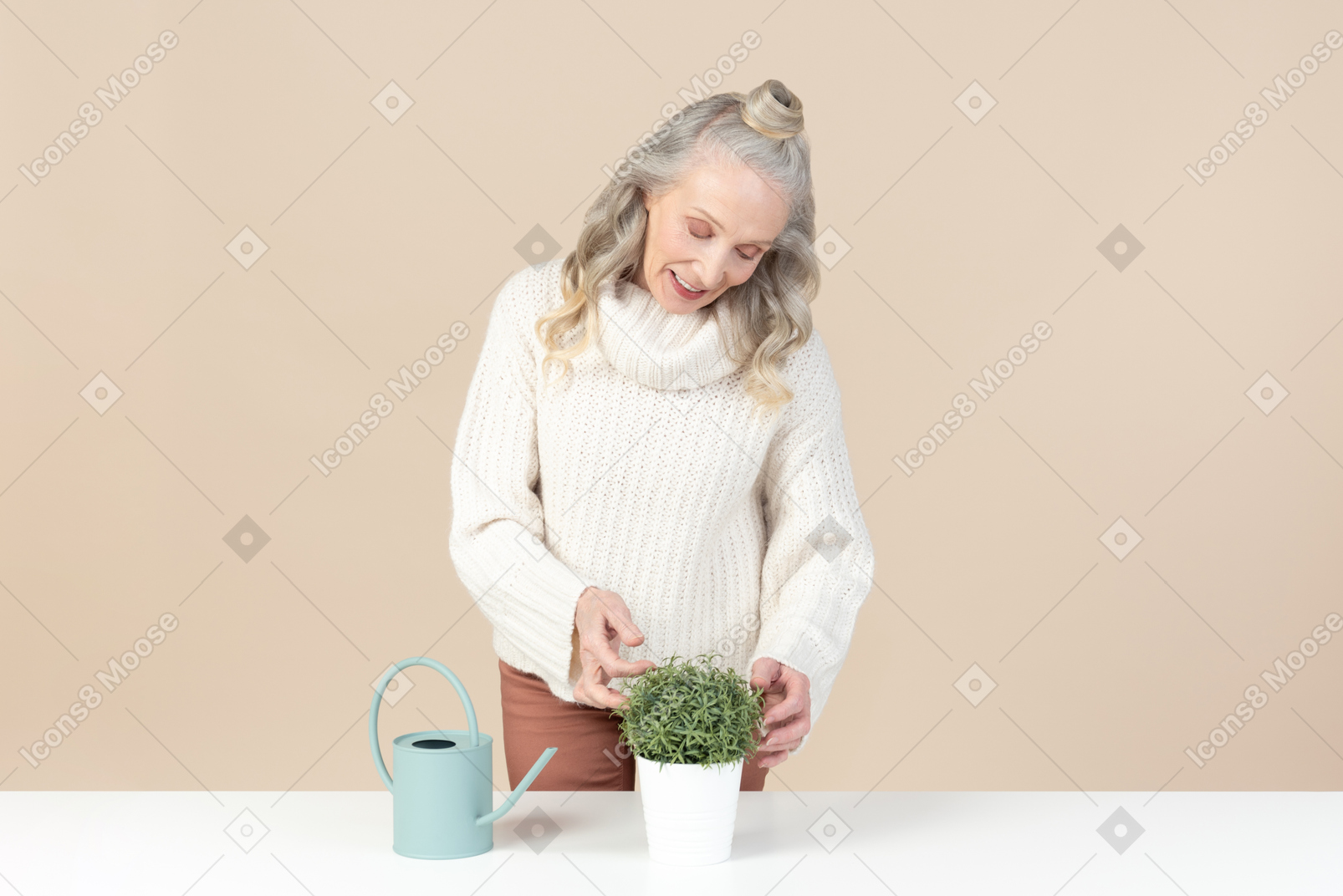 Smiling old woman taking care of plant