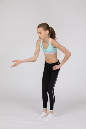 Side view of a teen girl in sportswear raising hand and arguing