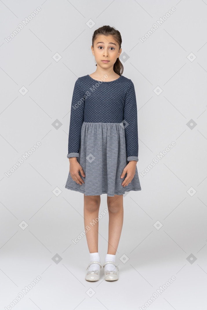 Surprised girl standing with arms at sides and facing the camera