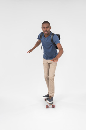 Black male tourist standing on skateboard