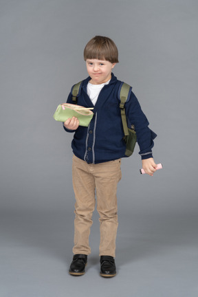 Colegial sosteniendo una pluma y una caja de lápices