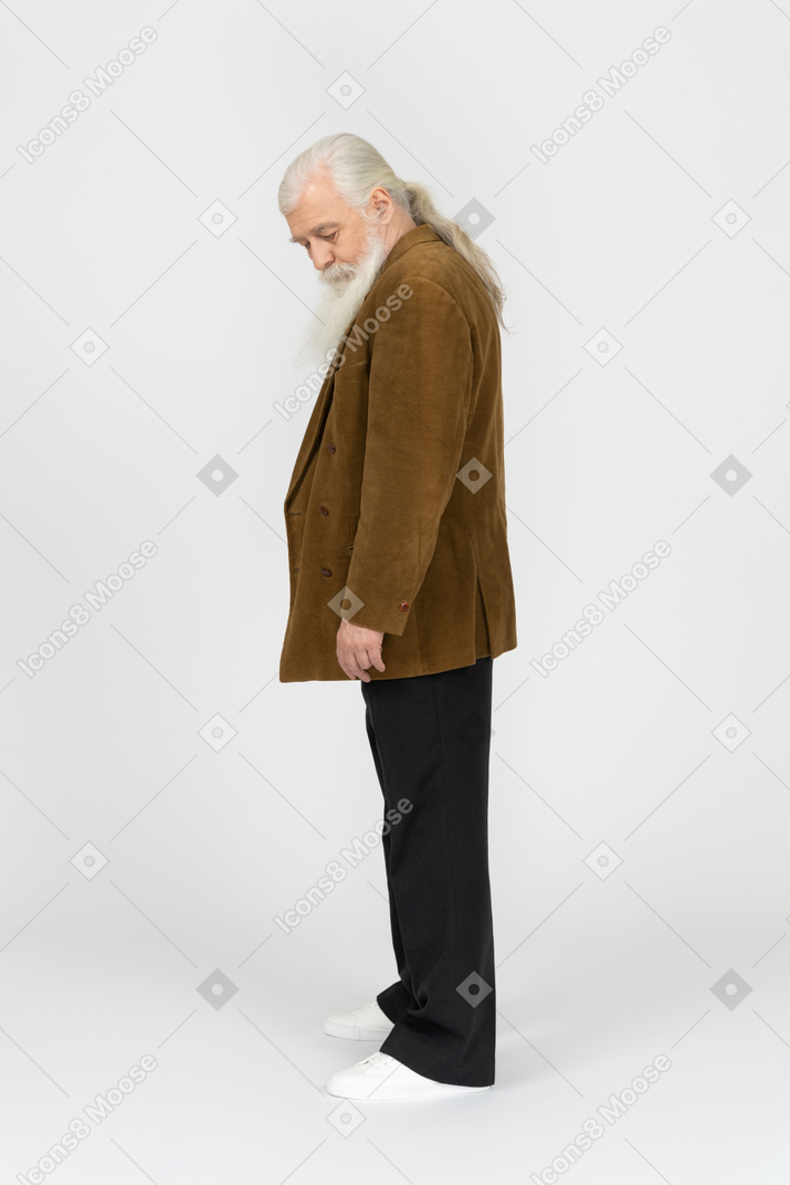 Vista lateral de un anciano mirando hacia abajo