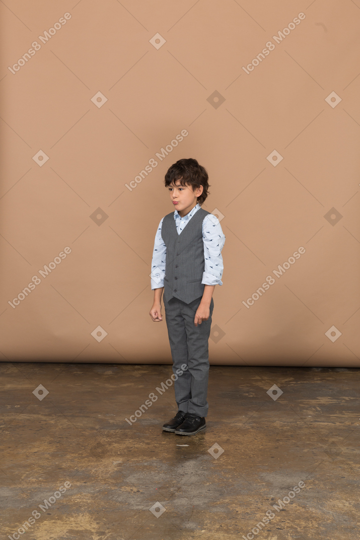 Vorderansicht eines jungen im grauen anzug, der still steht
