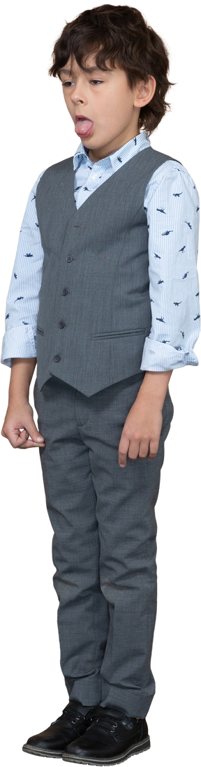 一个穿着灰色西装、露出舌头的可爱男孩的前视图