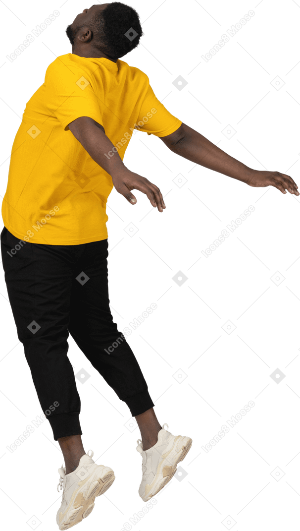 Три четверти сзади прыгающего молодого темнокожего мужчины в желтой футболке с раскинутыми руками
