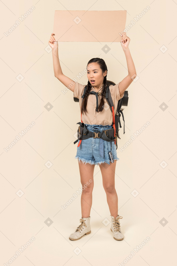 Jovem hitchhiker feminino segurando o cartão de papel