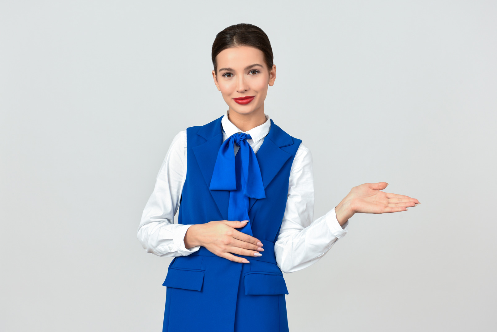 Young flight attendant giving in-flight safety demonstration