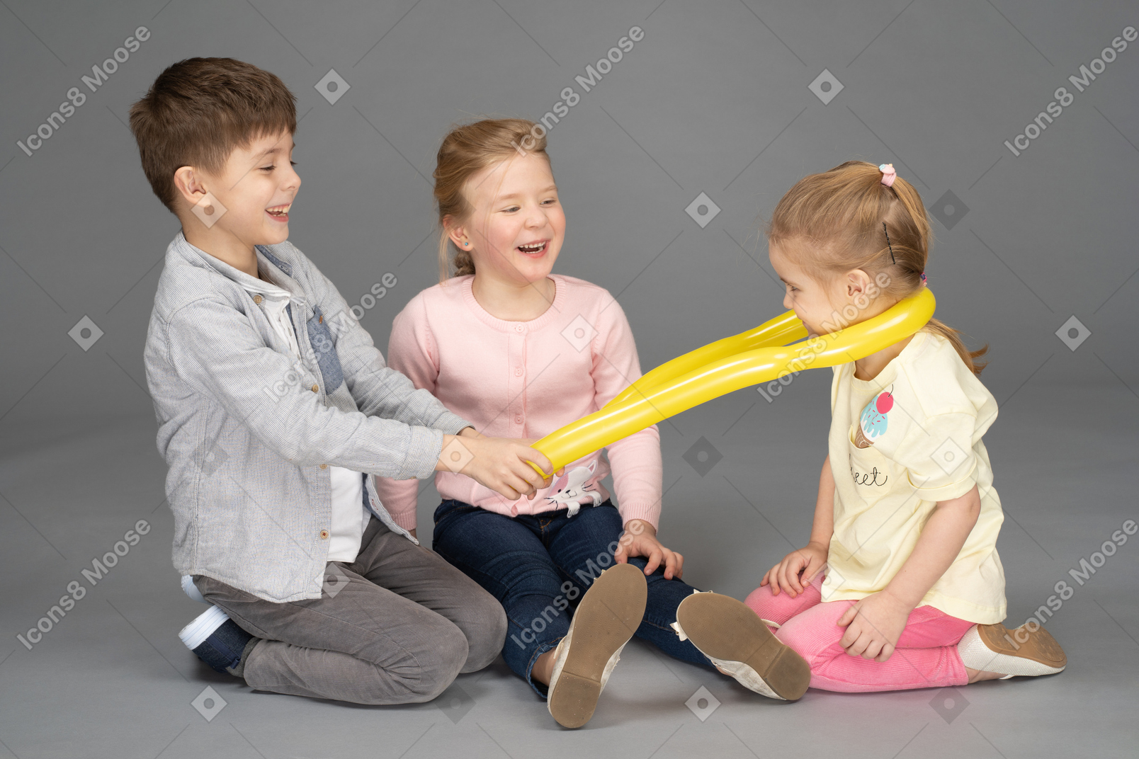Crianças se divertindo brincando com balão amarelo