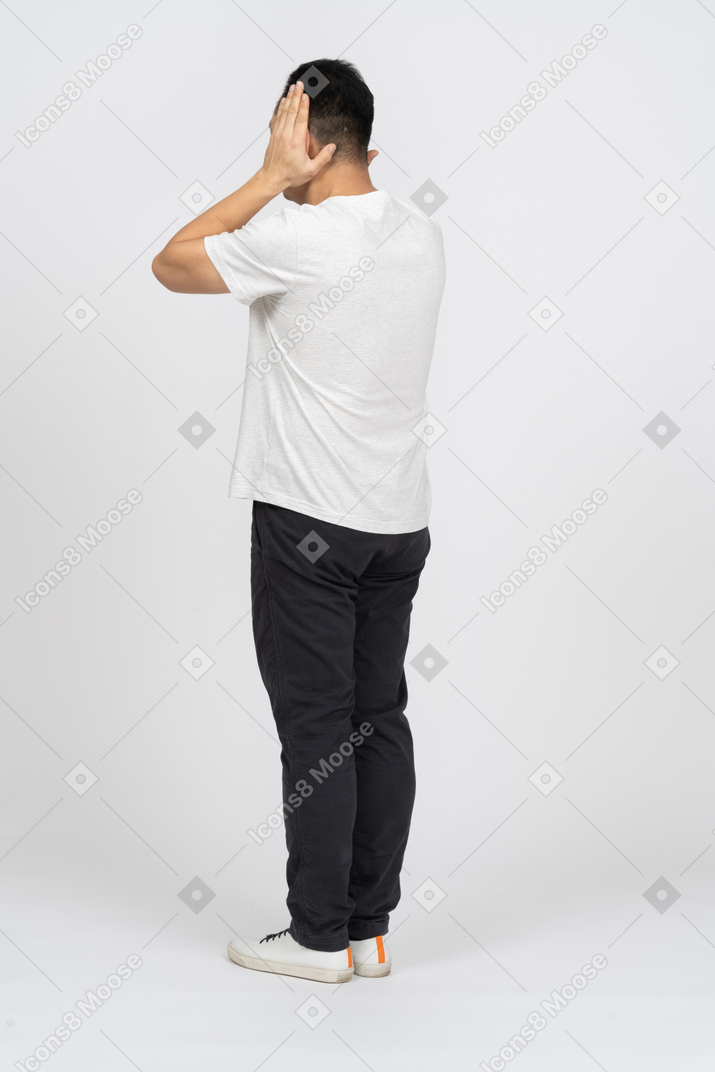 一个穿着休闲服的男人用手捂住耳朵的四分之三视图