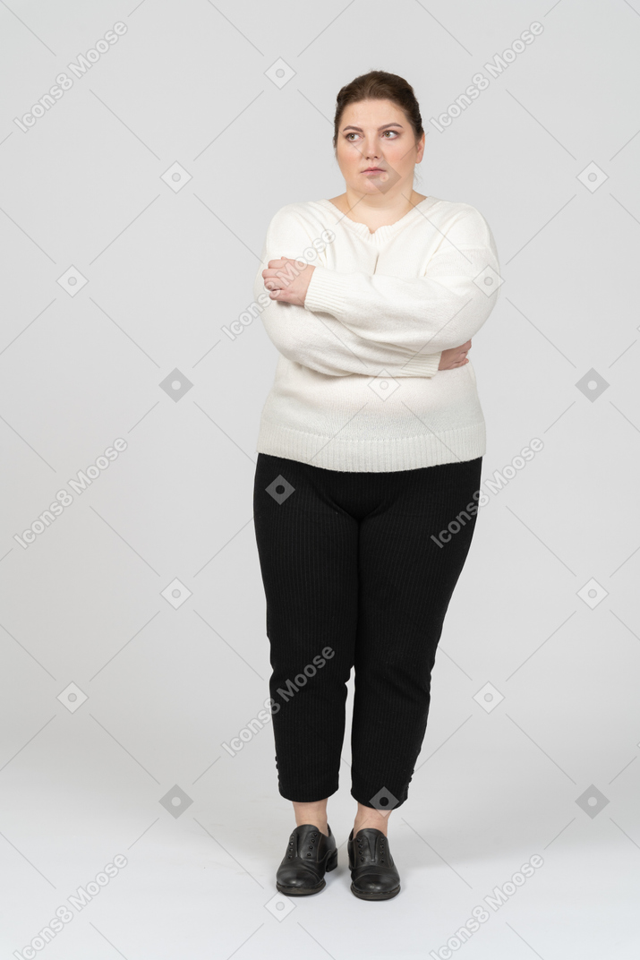 Mujer regordeta en ropa casual manteniendo los brazos cruzados