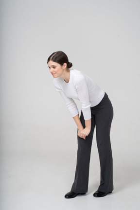 Front view of a woman in suit bending down