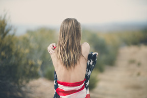 Femme enveloppée dans un drapeau américain