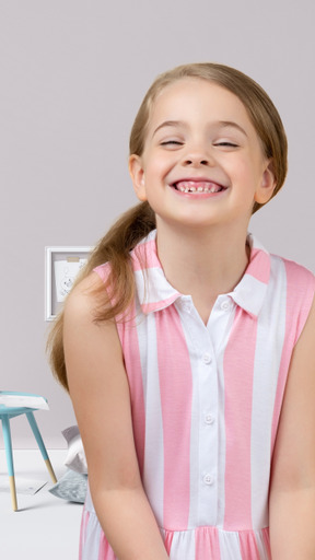 A little girl wearing a pink and white striped dress