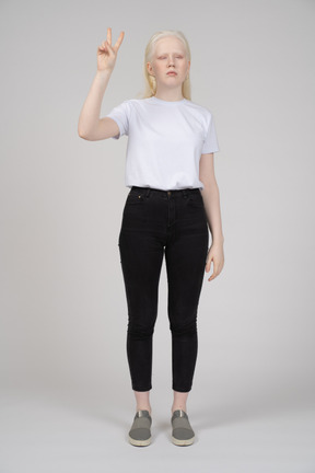 Young girl standing with v hand sign