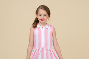 Little girl with lipstic on standing and smiling