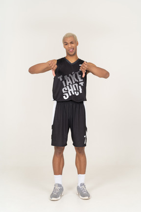 Vista frontal de um jovem jogador de basquete mostrando os polegares para baixo