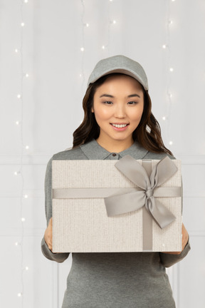 Asiatische frau, die weihnachtsgeschenk bringt