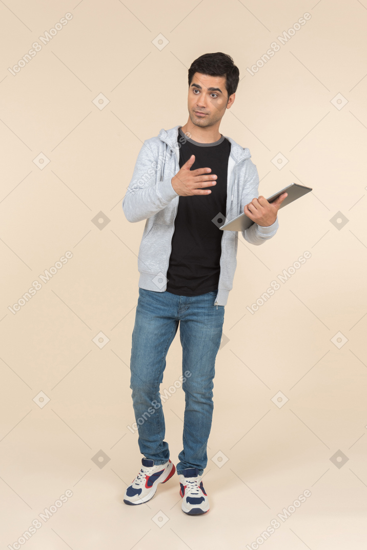 Молодой человек кавказской, указывая на цифровой планшет он держит