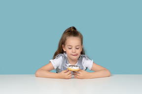 Cute little girl looking at a doughnut