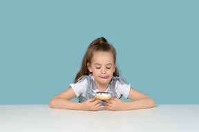 Niña linda mirando un donut