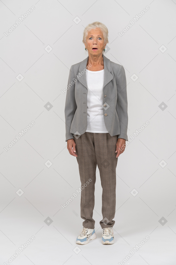 Front view of an old woman in suit standing with open mouth