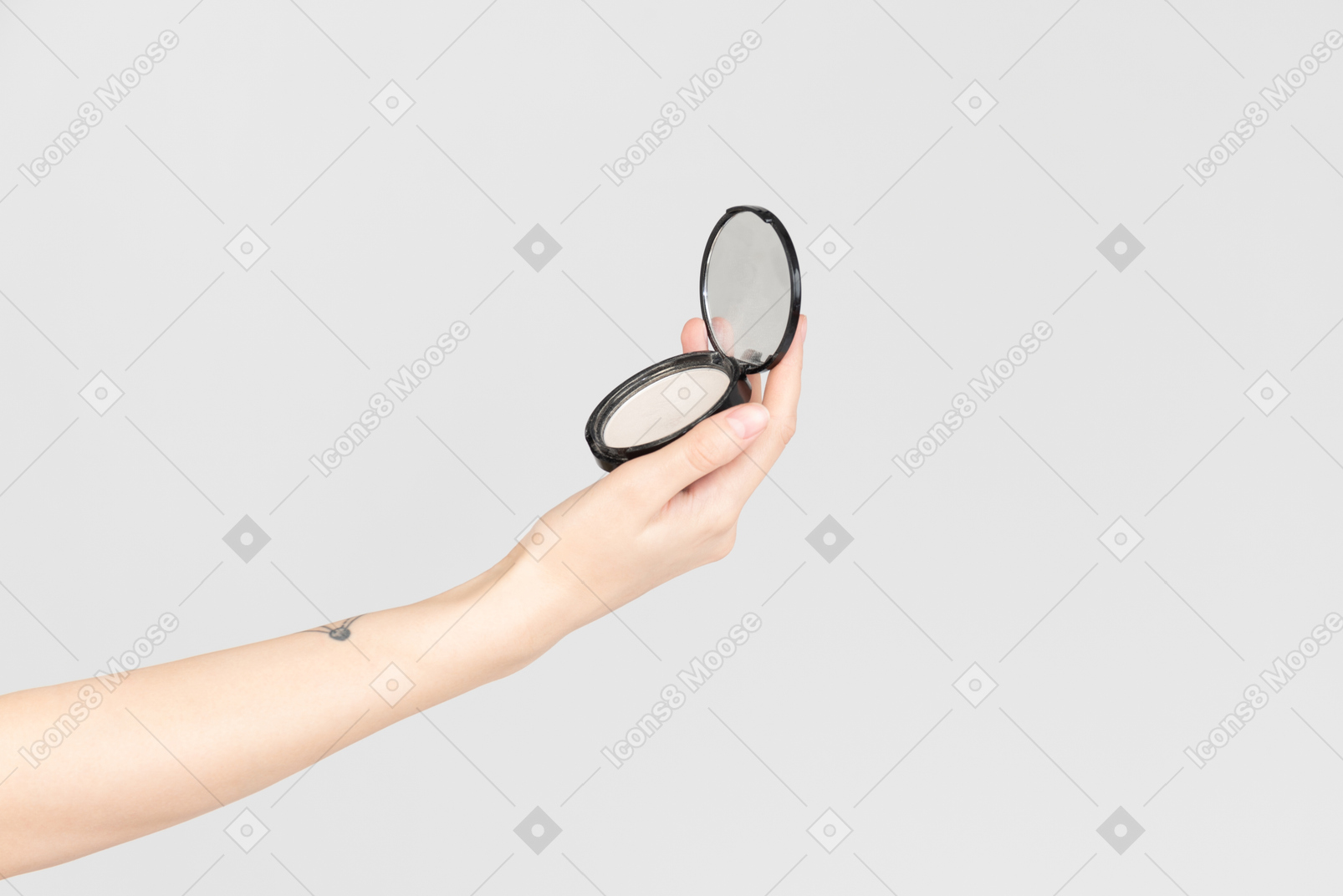 Main féminine tenant un miroir de poche