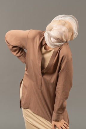 Young woman in beige clothes with shawl covering her head