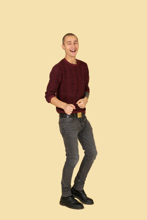 Three-quarter view of a young laughing man in red pullover