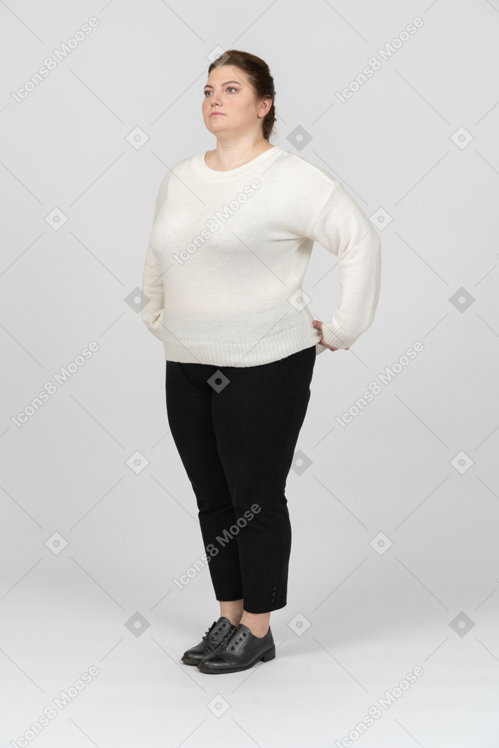 立っているカジュアルな服を着たふっくらとした女性の側面図