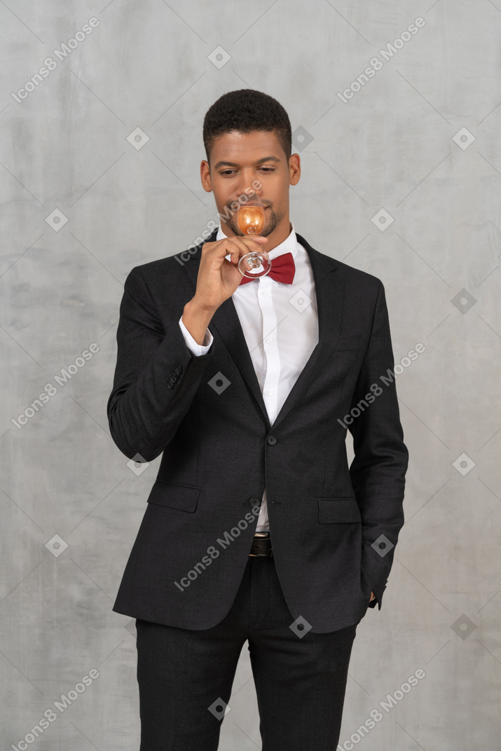 Smiling young man drinking from a champagne glass