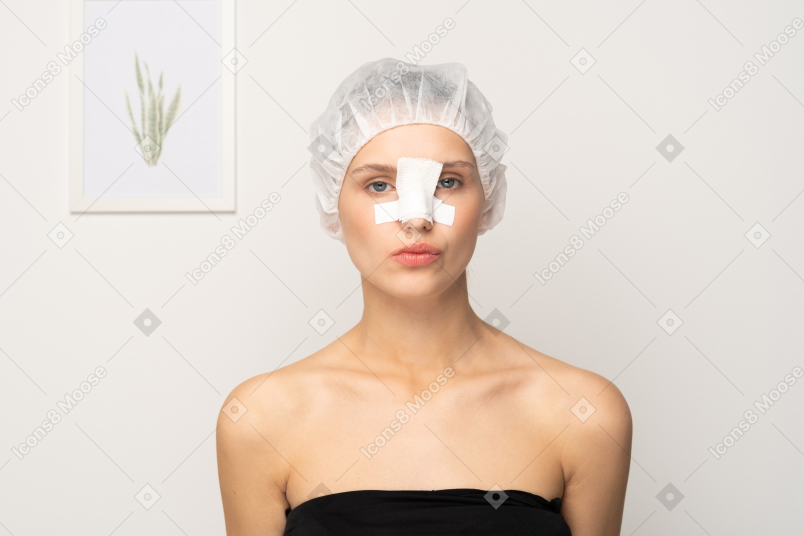 Female patient in medical cap with an adhesive bandage on her nose