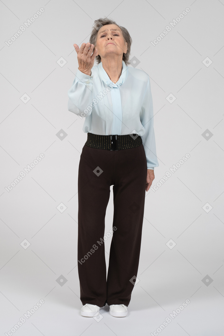 Front view of an old woman reaching out theatrically