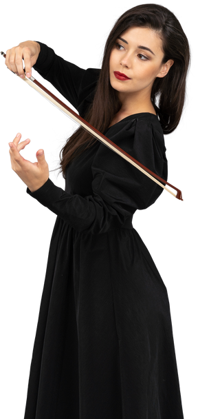 Vista de três quartos de uma jovem de vestido preto dando a impressão de tocar violino