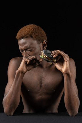 Vista frontal de un joven afro comiendo una hamburguesa