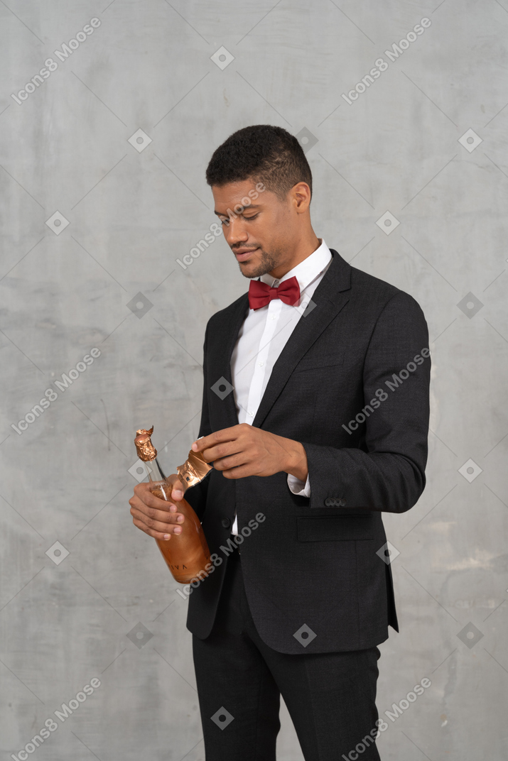 Man removing foil wrapping from champagne bottle