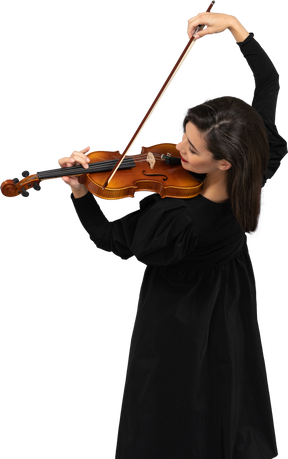 バイオリンを弾く黒いドレスを着た若い陽気な女性のクローズアップ